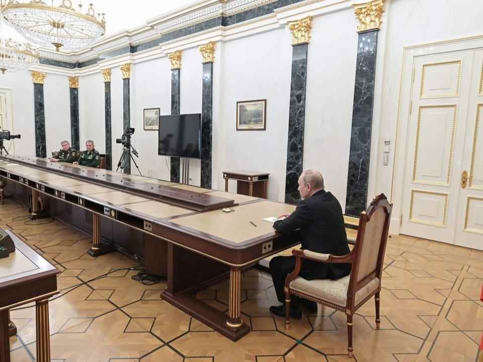 Gerasimov and Shoigu are sitting at a long table, at the end of which sits President Putin.