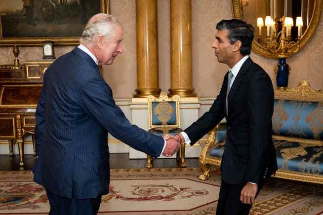 Rishi Sunak accepts the government commission from King Charles III at Buckingham Palace.  opposite.