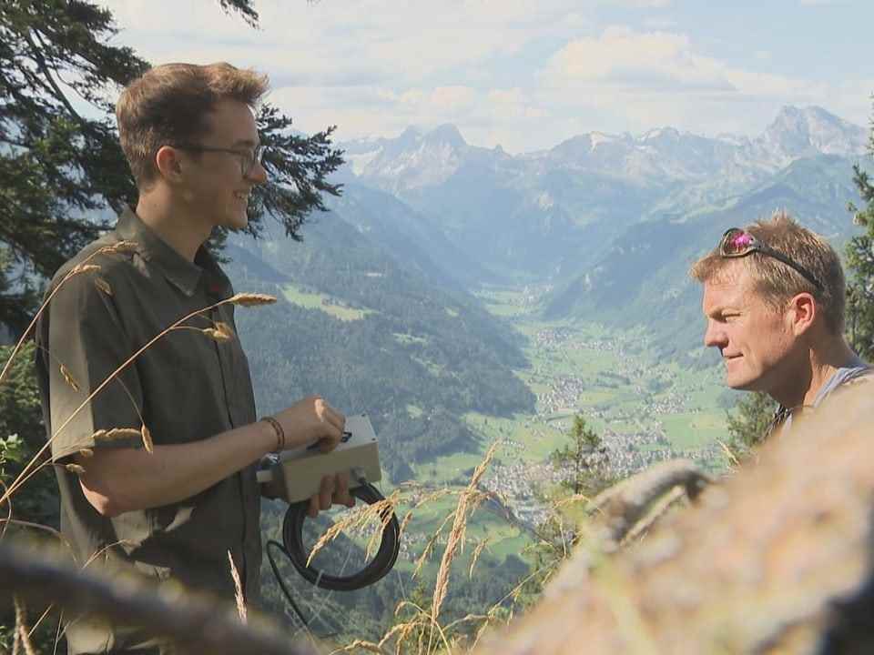 left startup founder with Smartmic from the side.  On the right a game warden on a mountain with a mountain panorama in the background.