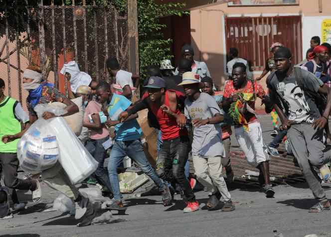 People flee after looting a hotel on the sidelines of a protest demanding the resignation of Haitian Prime Minister Ariel Henry after weeks of shortages, in Port-au-Prince, October 10, 2022.