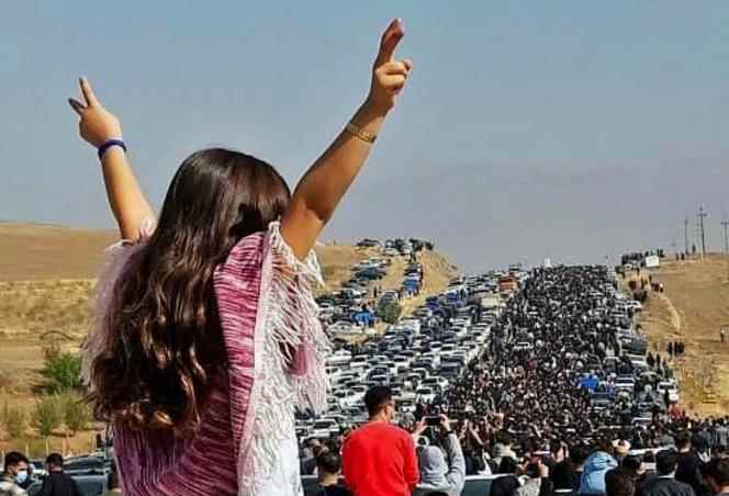 In this image posted on Twitter, October 26, 2022, a woman appears unveiled, as thousands of Iranians commemorate the 40th day of the death of Mahsa Amini at the Aichi cemetery, in Saqez (in Iranian Kurdistan), the hometown of the young woman.