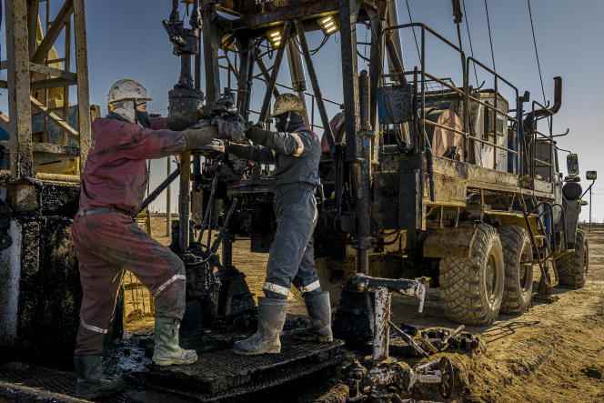 Maintenance workers repair an oil extraction pump in Janaozen, Kazakhstan, February 25, 2022.