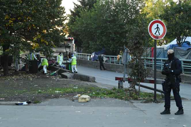 Municipal workers clean the Place du Jardin Forceval during the dismantling of a camp for crack addicts, in Paris, on October 5, 2022.