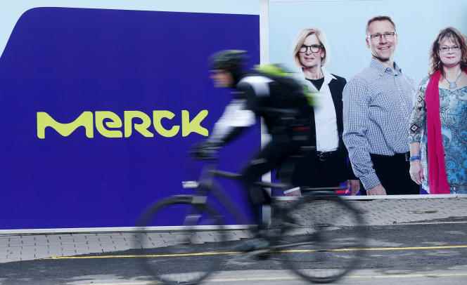 A cyclist rides past a logo of the pharmaceuticals and chemicals group Merck KGaA in Darmstadt, Germany, January 28, 2016. 