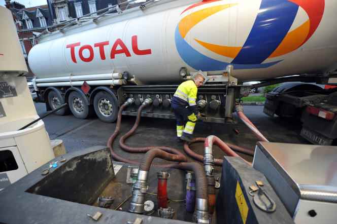 A Total employee refuels a gas station from a tank, in February 2011, in Lille.
