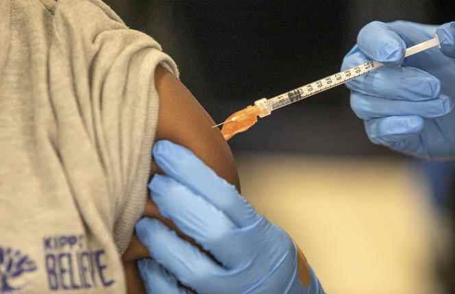 A patient receives a dose of vaccine at a school in New Orleans, United States, January 25, 2022. 