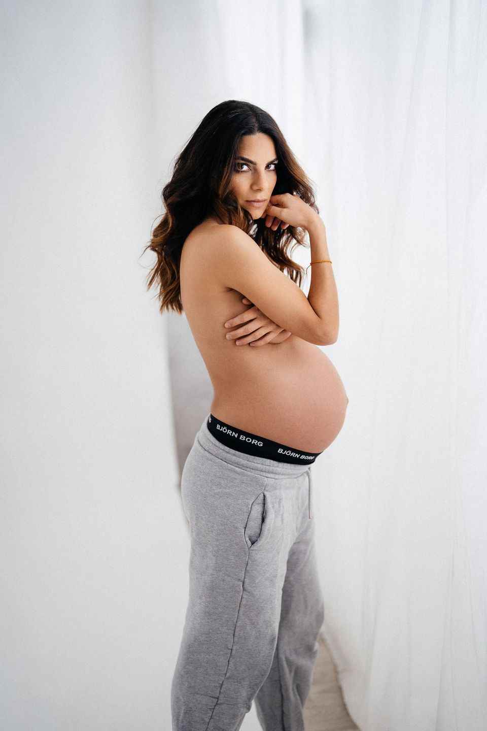 Dressed only in jogging pants, Lilli Hollunder puts her big baby bump in the limelight.