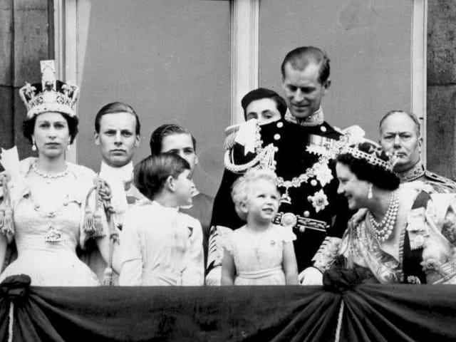 Queen Elizabeth stands on a balcony with her husband, son, daughter and mother.