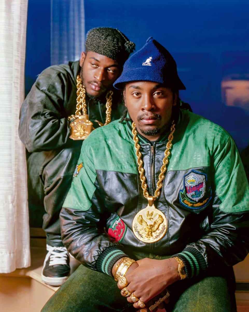 Two men in colorful jackets with gold chains