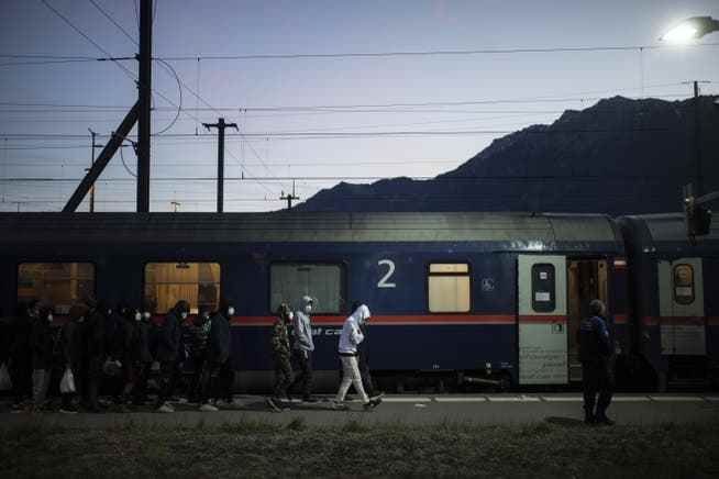Schweizer Grenzwächter bringen Migranten aus einem Zug aus Wien zur Kontrolle am Bahnhof in Buchs.