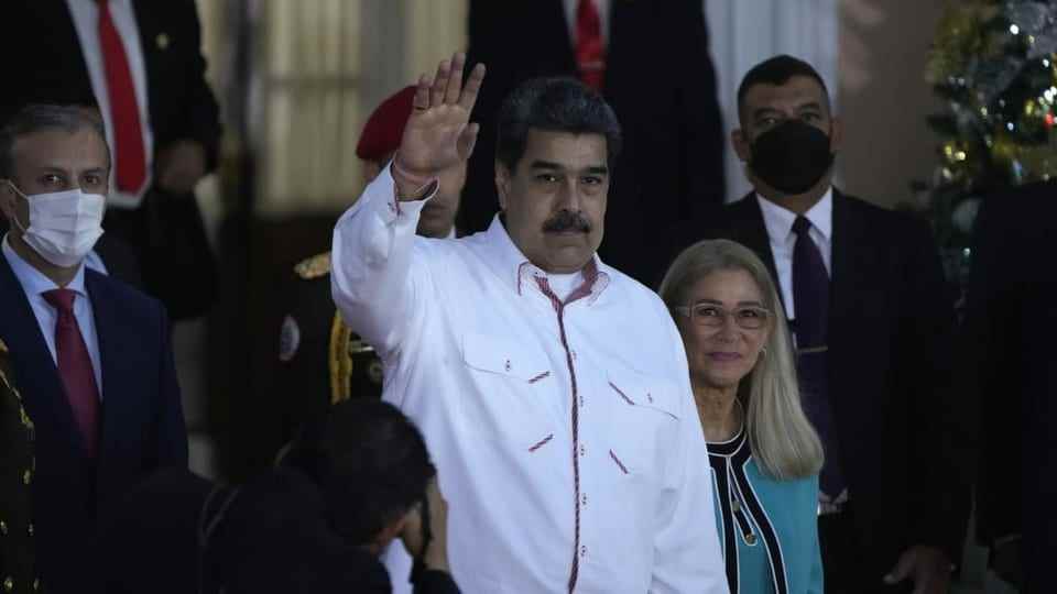 Venezuelan President Nicolas Maduro, accompanied by First Lady Cilia Flores, waves in Caracas,