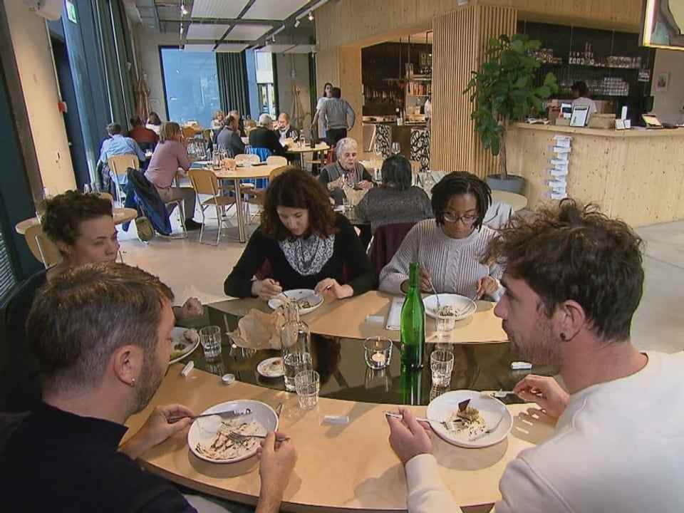 Guests sit around a table and eat. 
