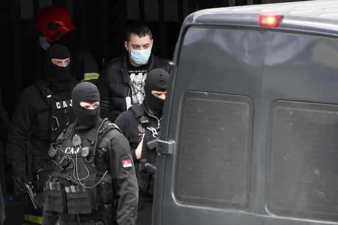Serbian police officers escort Veljko Belivuk, leader of the ultra supporters of Partizan, a Belgrade football club that has become a beacon of the underworld, during a raid on the Partizan stadium in Belgrade on February 4, 2021.