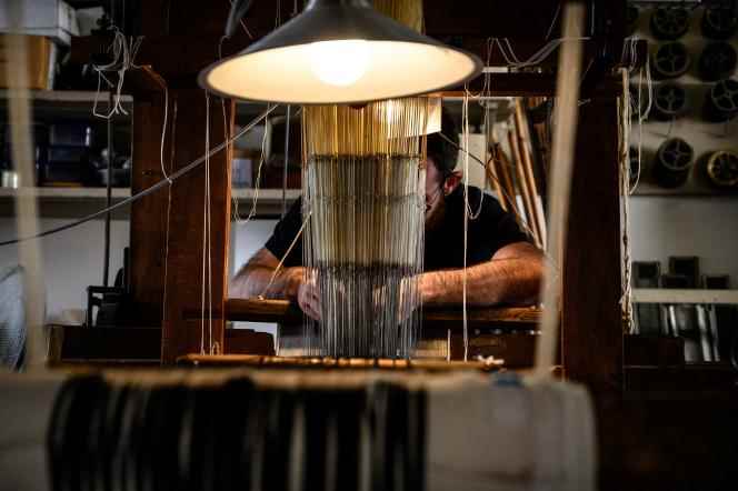 A craftsman works on his silk weaving machine in the Prelle factory in the Croix-Rousse district of Lyon on September 16, 2019. 