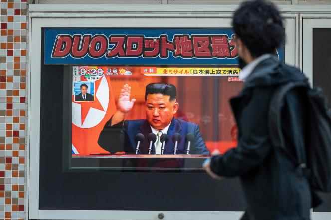 A passerby in a Tokyo street watches North Korean leader Kim Jong-un's speech on the new missile launches.