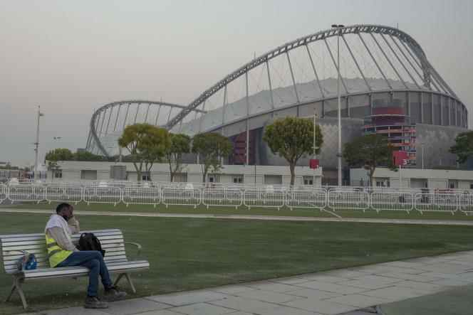 A migrant worker rests on a bench outside Khalifa Stadium, before returning to work, Saturday October 15, 2022.