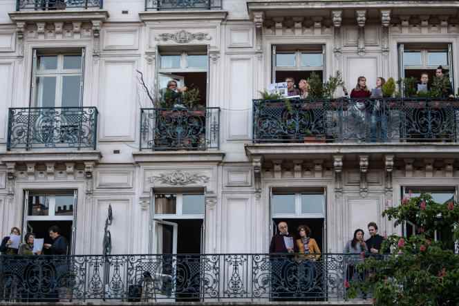 Neighbors sing on their balconies on Labor Day, May 1, 2020 in Paris, the 46th day of strict confinement, in France, to stop the spread of Covid-19.
