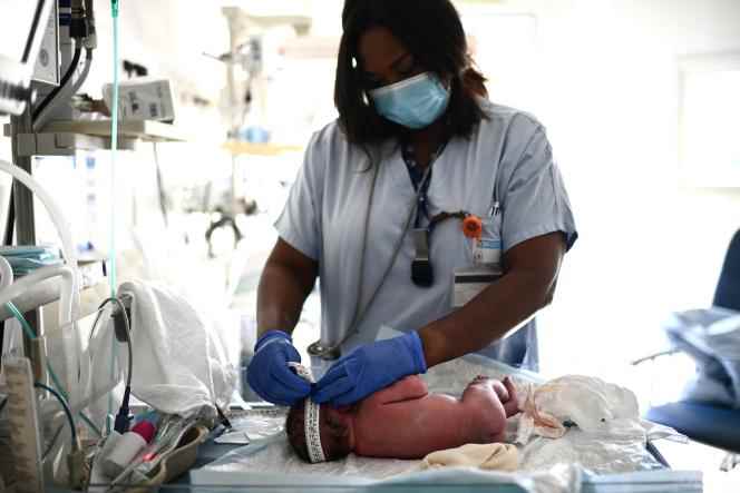 A nurse takes care of a newborn baby in the maternity ward of a hospital in Paris on June 29, 2022. 