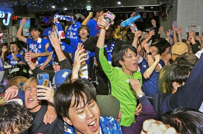 Japanese fans celebrate the 2-1 win over Spain at a bar in Osaka. 