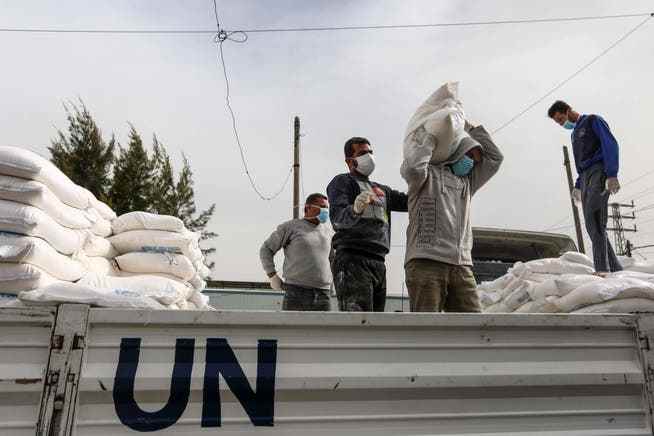 Mitarbeiter des Hilfswerks für Nahost bringen im Gazastreifen Nahrungslieferungen aus.