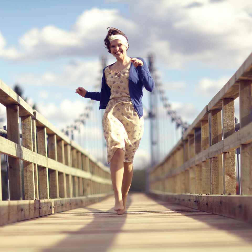 With this lucky trick you can go through life happier: A woman dances across a bridge