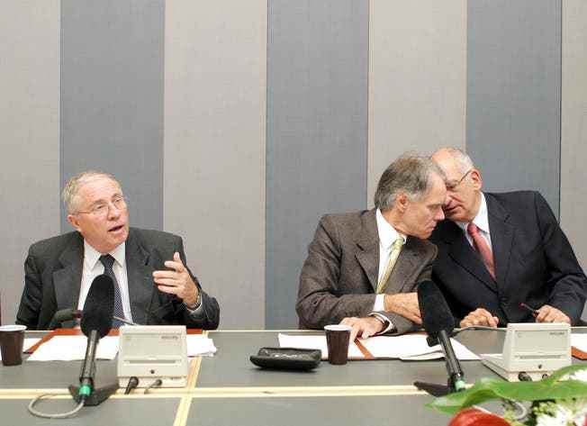 Christoph Blocher speaks alone while his Federal Council colleagues Moritz Leuenberger and Pascal Couchepin whisper together. 