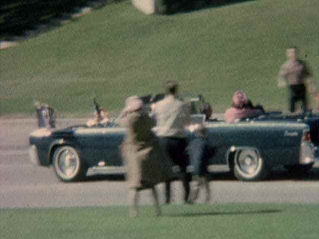 John F. Kennedy lies injured in the presidential limousine.