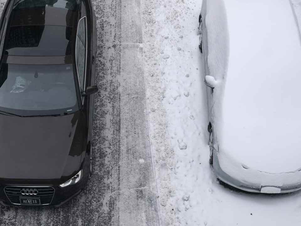 A clean car overtakes a snow-covered car