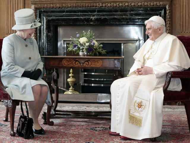 The Queen and the Pope sit opposite each other.