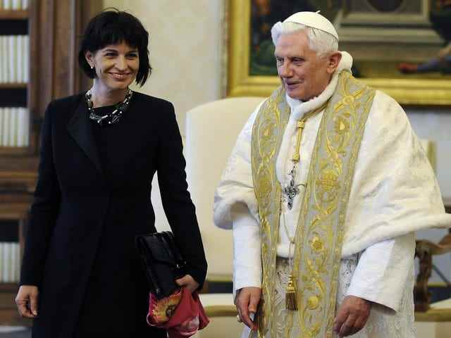 Both smile.  Leuthard wears black, the Pope white and gold.