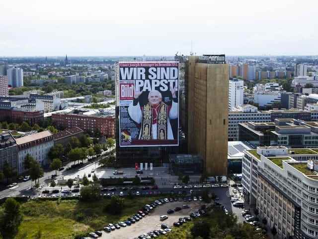 A huge poster hangs on a high-rise building.