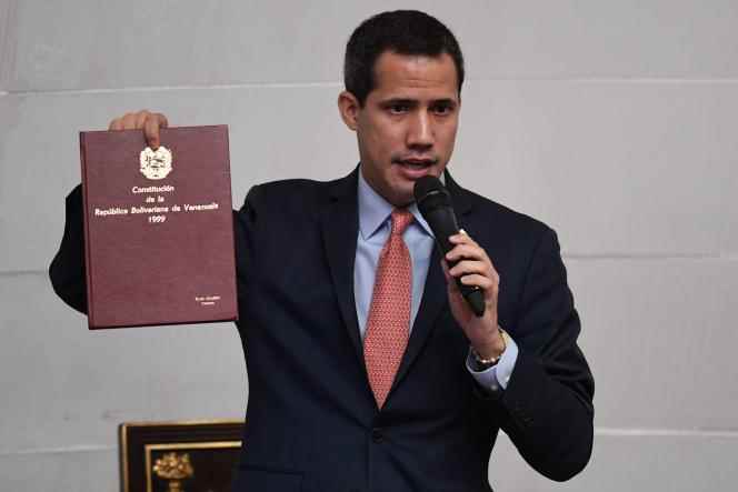 Venezuela's opposition leader and self-proclaimed president Juan Guaido waves the Constitution at the National Assembly in Caracas on December 17, 2022.