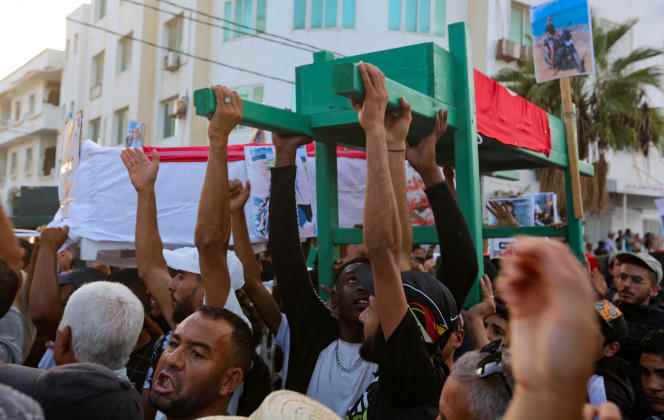 Tunisians carry a fictitious coffin and photos of the victims during a demonstration demanding clarification of the disappearance of 12 people at sea in September.  In Zarzis, Tunisia, November 4, 2022. 
