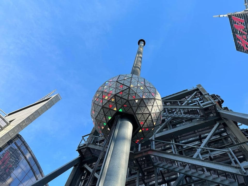 A large globe hangs from a pole in Times Square, New York.
