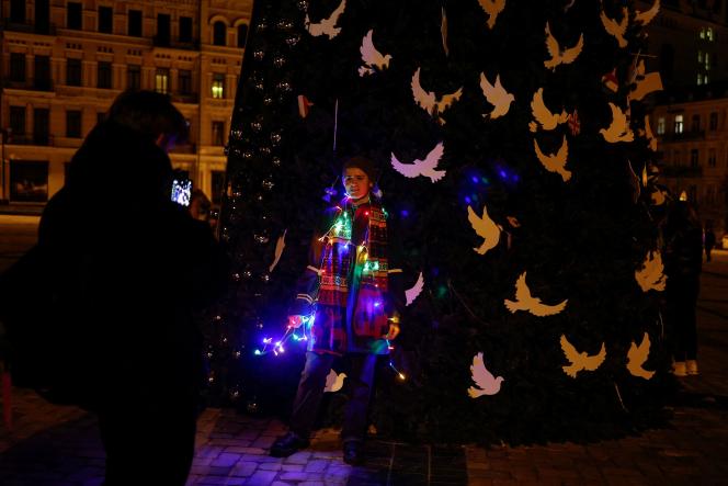 A woman poses for a photo a few hours before curfew in kyiv, in front of Saint Sophia's Cathedral, Saturday, December 31, 2022. 