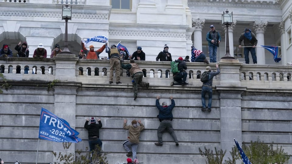 Trump supporters climb the Capitol parapet