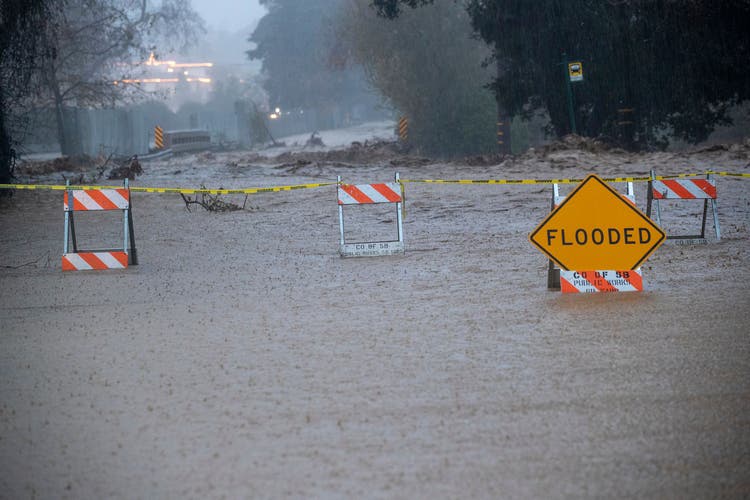 In Montecito, due to heavy rainfall, an adjacent stream overflowed and flooded the street.