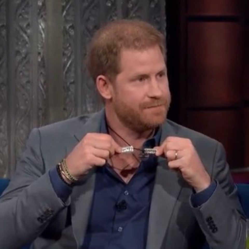 Prince Harry shows the two new pendants on his chain: cardiograms with the heartbeats of his two children, a gift from his wife Meghan. 