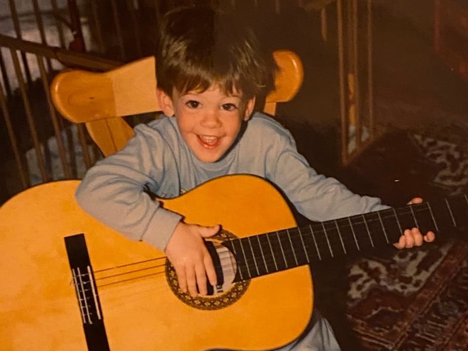 Photo of little boy playing guitar