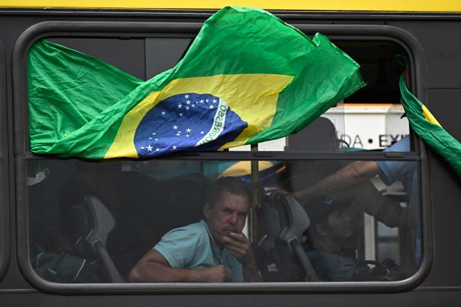 Supporters of former Brazilian President Jair Bolsonaro are taken by police on a bus for identity checks after the attack on official state buildings in Brasilia on November 9, 2023. 