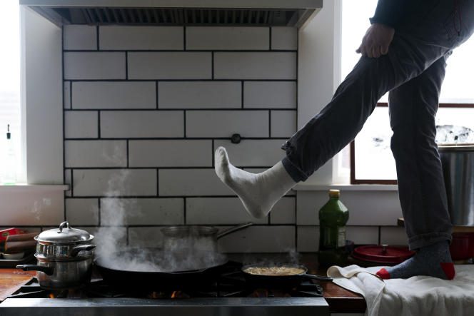 A man warms his feet over a gas stove, in Austin, Texas on February 16, 2021.