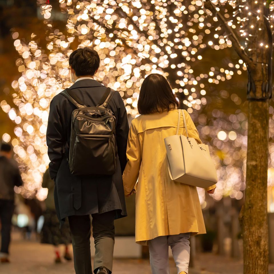 A couple walks through a romantically lit city center