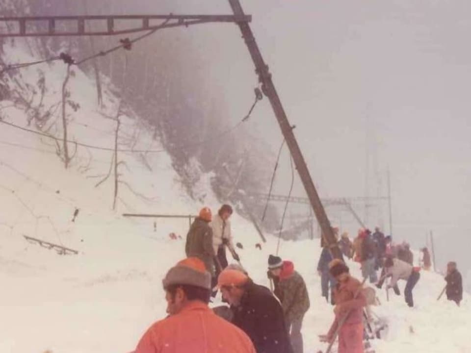 Photo from 1975: People are digging out a railway track that was buried by an avalanche.