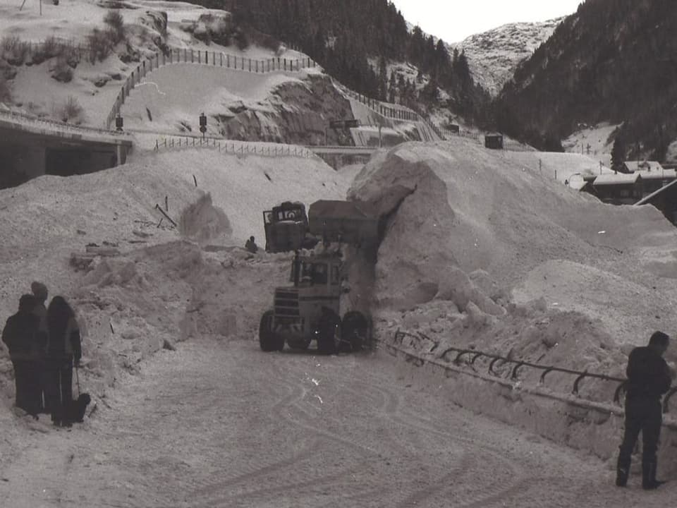 Black and white photo: excavators at work clearing away the avalanche.