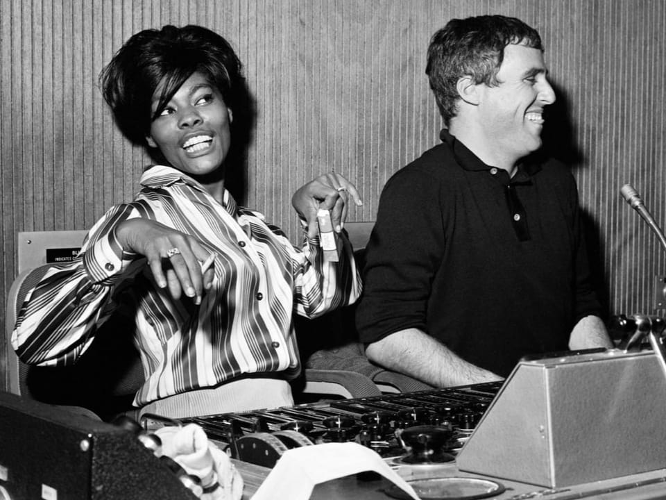 Cheerful young woman and cheerful man at a recording desk (black and white photo)
