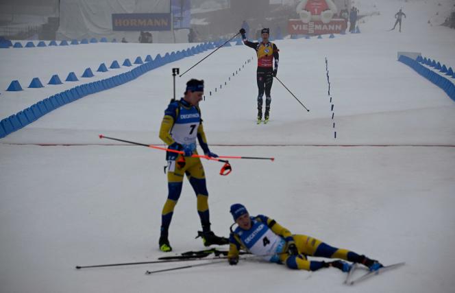 Johannes Boe crosses the finish line of the mass start, Sunday February 19, 2023, after the Swedes Martin Ponsiluoma (on the left, 2nd) and Sebastian Samuelsson (on the right, the winner), in Oberhof, Germany. 