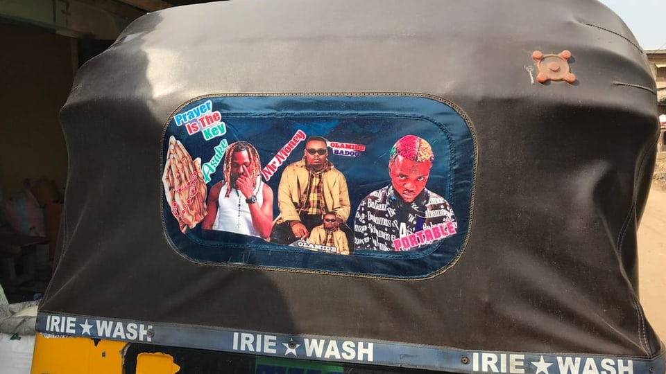 Various musicians are depicted on the rear window of a tuktuk