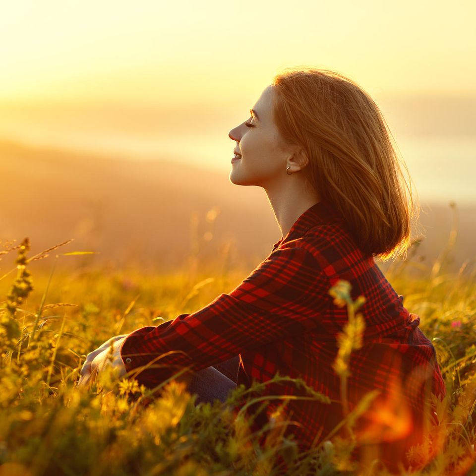 woman sitting in field |  This is how you manifest your dream life