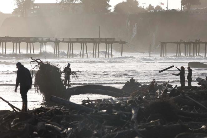 Picking up debris on a beach after the deluge hit the area, in Capitola, Calif., January 10, 2023.