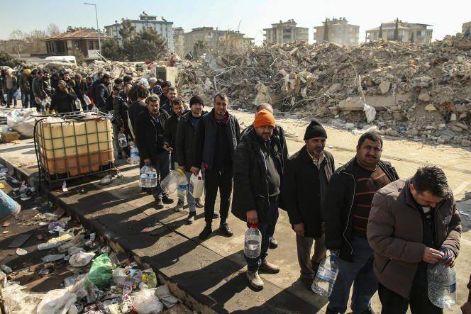 People queuing for water near collapsed buildings in Kahramanmaras, Turkey, February 12, 2023.
